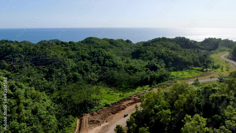 Dig site of new road under construction in vibrant forest area of Indonesia, aerial view Dig site of new road under construction in vibrant forest area of Indonesia, aerial view