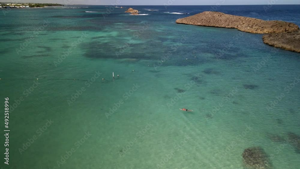 DRONE BEACH TAKE OF MAN SWIMMING IN CRYSTAL CLEAR BLUE WATER BEACH DRONE BEACH TAKE OF MAN SWIMMING IN CRYSTAL CLEAR BLUE WATER BEACH