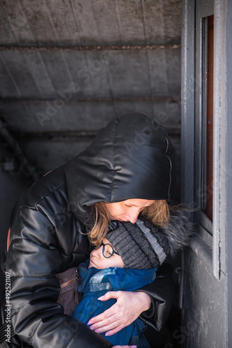 Mom with boys in a bomb shelter. Ukraine war with Russia. People are hiding in basements.