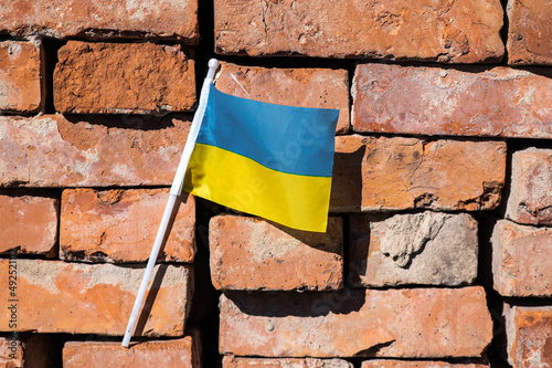 Ukrainian flag on a red brick wall background.