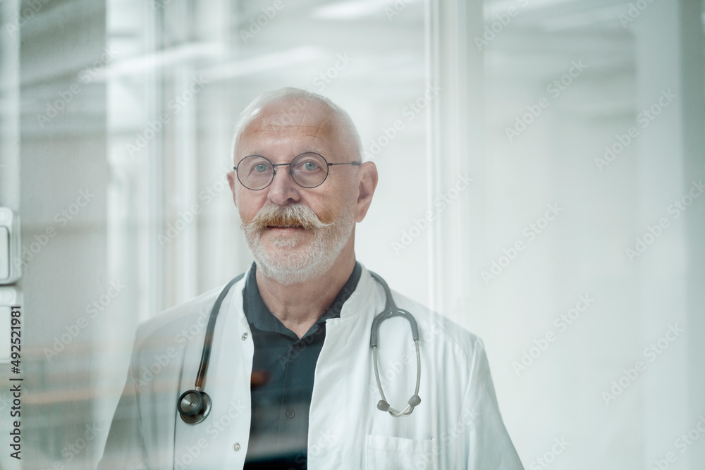 Senior doctor with mustache wearing eyeglasses at medical clinic Senior doctor with mustache wearing eyeglasses at medical clinic