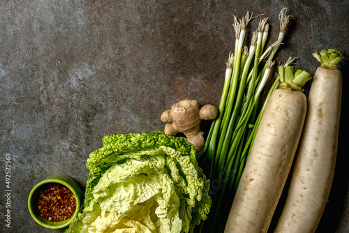 Ingredients for kimchi. Fresh vegetables, traditional Korean food in top view on wooden table copy space.