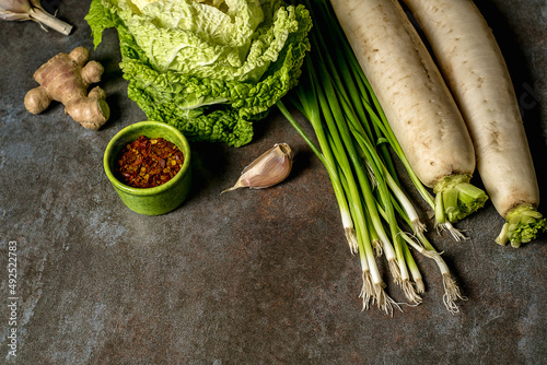 Ingredients for kimchi. Fresh vegetables, traditional Korean food in top view on wooden table copy space.