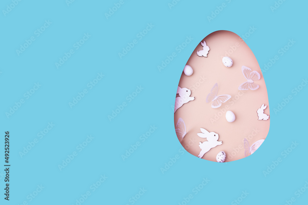 Easter egg cut out of paper and eggs, bunny and butterflies. Creative Easter holiday concept with copy space Easter egg cut out of paper and eggs, bunny and butterflies. Creative Easter holiday concept with copy space