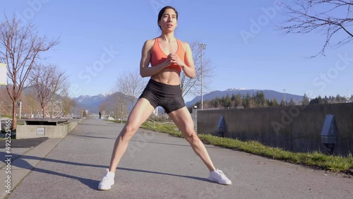Hispanic woman doing lateral lunges in outdoor park