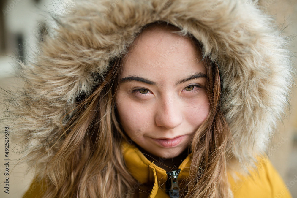 Close-up of young woman with Down syndrome weraing hood and looking at camera Close-up of young woman with Down syndrome weraing hood and looking at camera