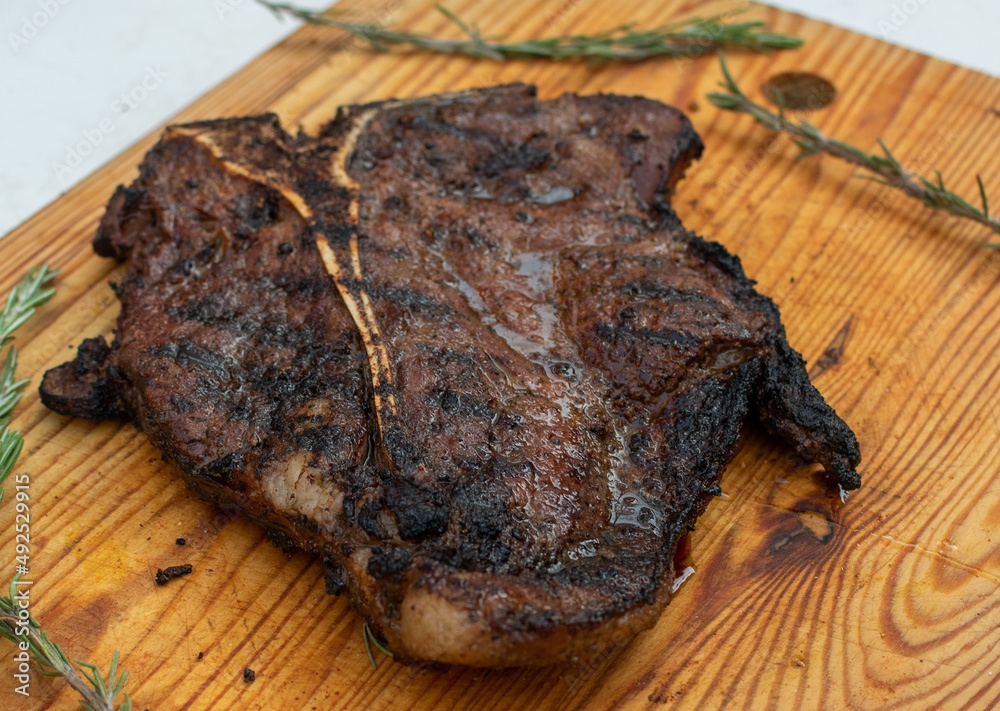 corte de res T bone. T bone corte en el asador corte al carbón manos