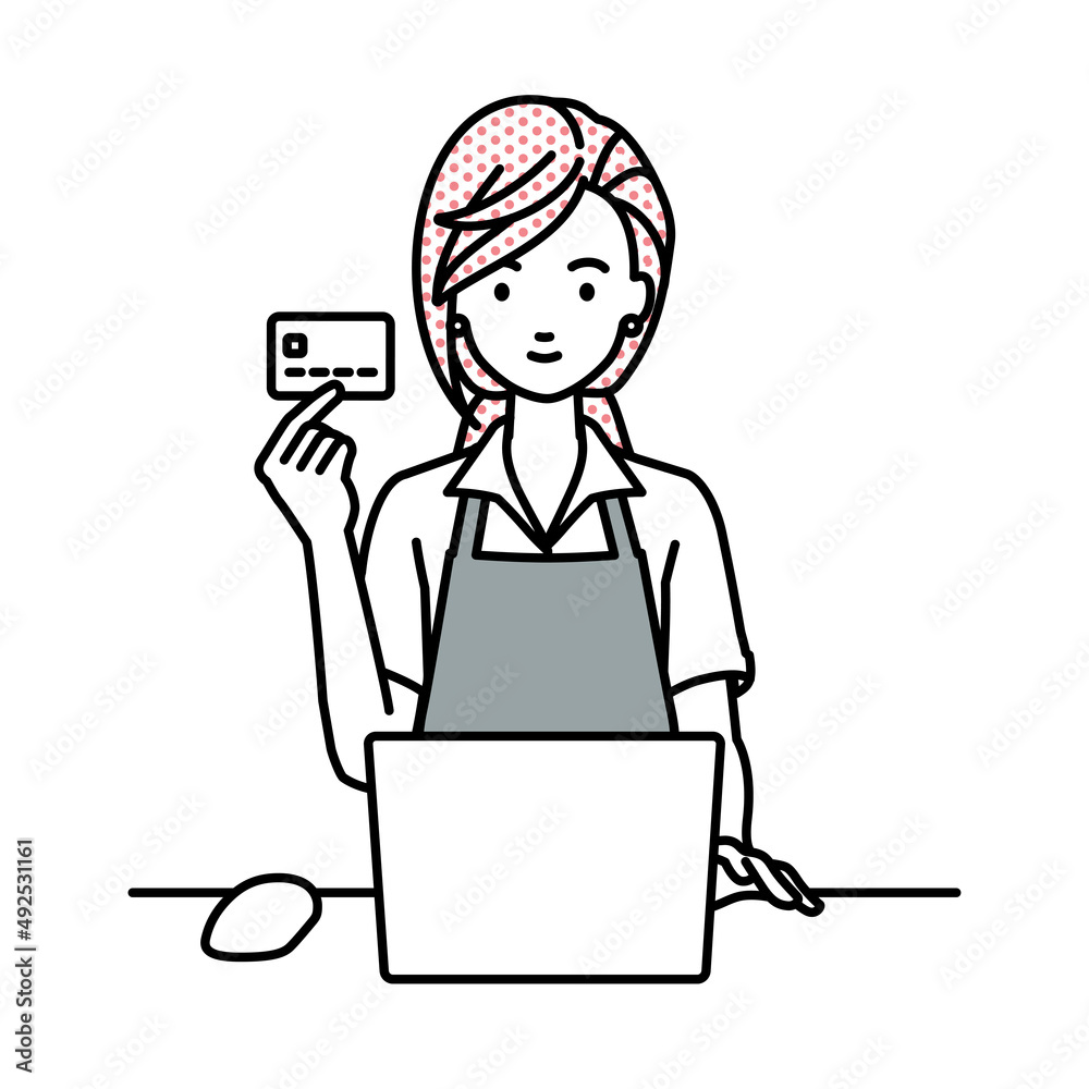 デスクで座ってPCを使いながらクレジットカードを手に持っている店員の女性