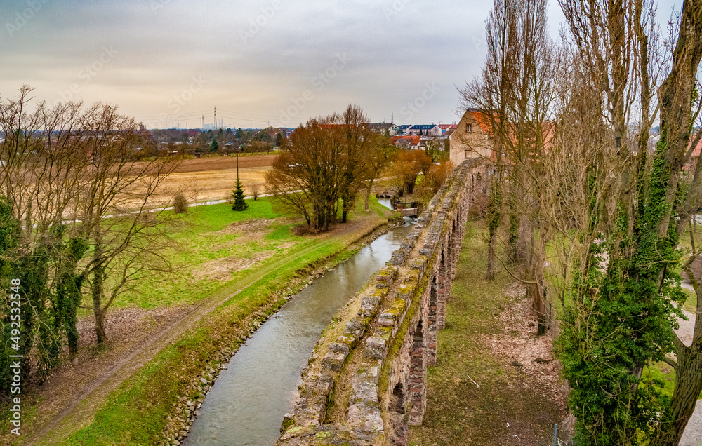 Lovely aerial view of the arches of the artificial ruins of the Roman water aqueduct along the Leimbach stream, also serving as a boundary for the English landscape garden of Schwetzingen Palace.