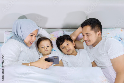 Muslim family using a smartphone before sleep