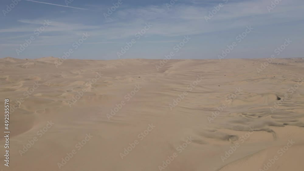 Dune buggies explore wide expanse of desert sand dunes, aerial view Dune buggies explore wide expanse of desert sand dunes, aerial view