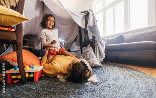 Happy little girl having fun with her mom during playtime