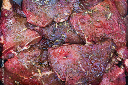 Pieces of juicy, fresh beef in spices, close-up. Beef raw steaks, top view.