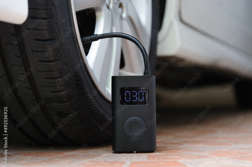 Portable cordless tire inflator. Portable air pump 素材庫相片 | Adobe Stock