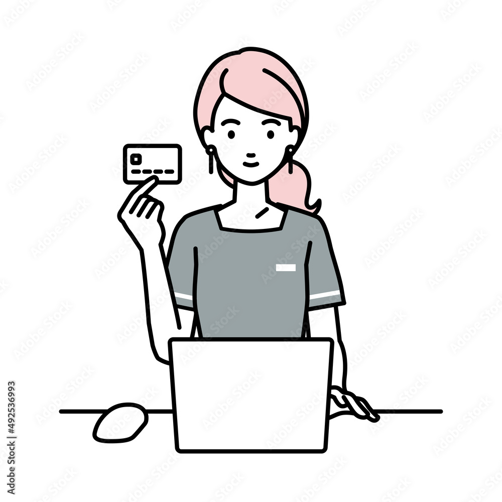 デスクで座ってPCを使いながらクレジットカードを手に持っているエステ店員・受付の女性 デスクで座ってPCを使いながらクレジットカードを手に持っているエステ店員・受付の女性