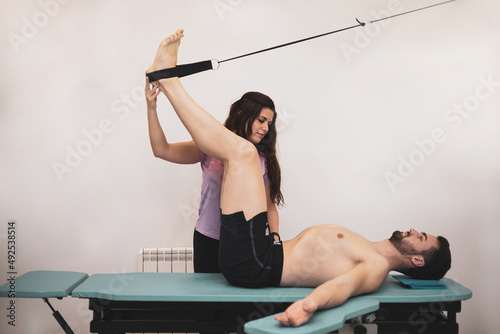 A young man undergoes a Global Postural Reeducation therapy to improve his posture and his body outline, necessary to avoid future pathology. photo