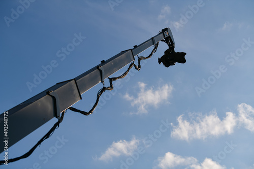 Fototapeta Naklejka Na Ścianę i Meble -  Crane broadcasting TV camera sistem used for filming from above, photographed against blue sky
