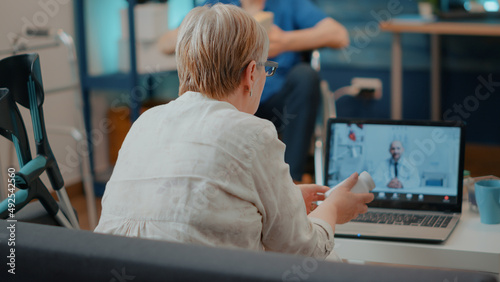 Senior adult meeting with specialist on online telemedicine call, using laptop computer. Retired woman talking to medic on remote teleconference for telehealth. Internet consultation.