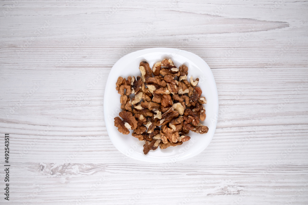 Walnuts on a white plate. A plate of nuts on the table. Healthy food. Man's health.