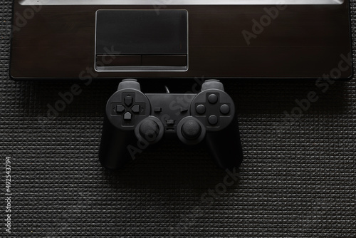 Gamepad controller notebook on black background. Smart tech.