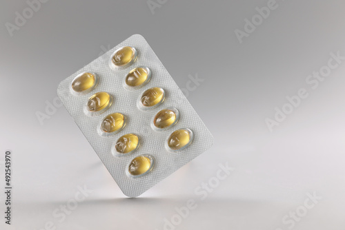 Blister with yellow jelly tablets, fish oil, daily dose of meds for person, pills in plastic package