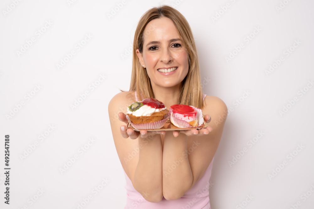 Image of happy woman in casual clothes holding piece of birthday cake isolated over white background. Celebration concept. Image of happy woman in casual clothes holding piece of birthday cake isolated over white background. Celebration concept.