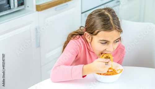 children in the kitchen at the table turning pasta.