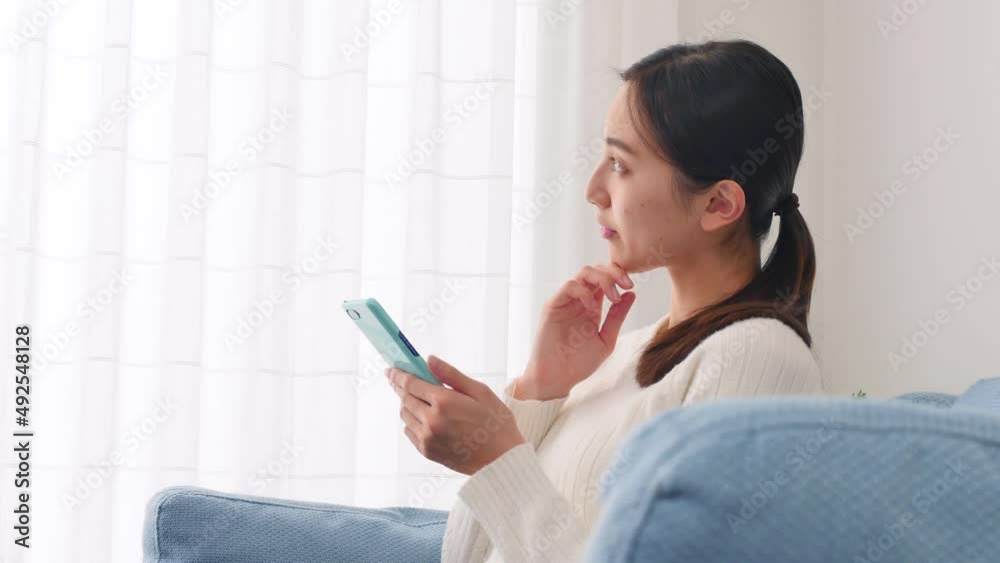 女性　スマホ　考える　リビング