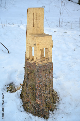 Chair is cut out with chainsaw frum tree stump photo