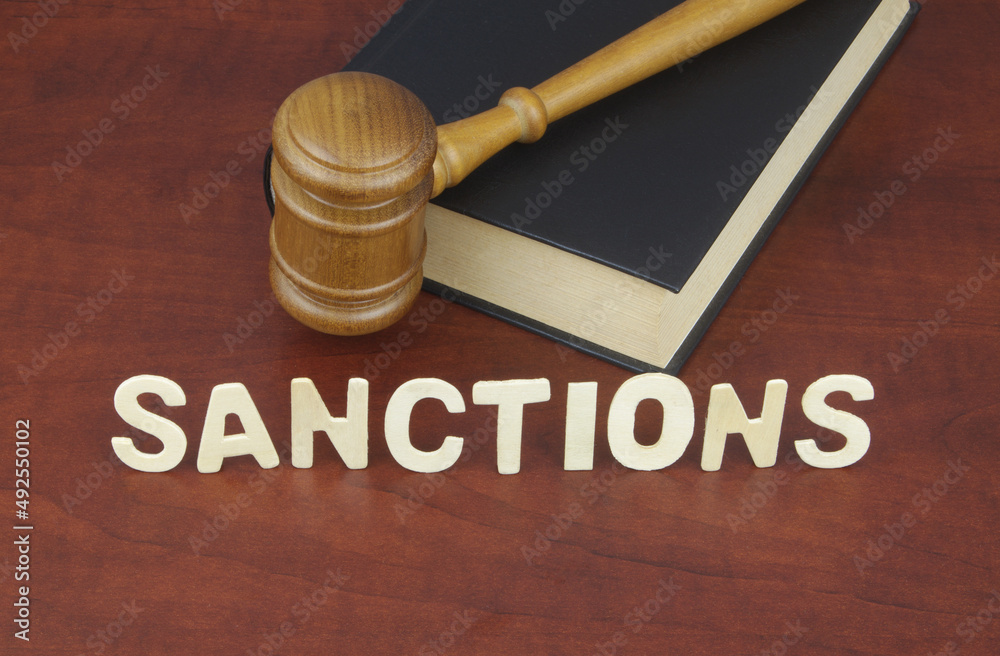 Sanctions theme, wooden judge on legal book and letters sanctions. Sanctions theme, wooden judge on legal book and letters sanctions.