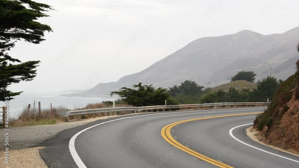 Pacific coast highway 1, Cabrillo road along ocean, foggy California, Big Sur, USA. Coastal road trip, traveling on car by sea. Cloudy misty weather. Yellow dividing line, asphalt. Turn of serpentine. Pacific coast highway 1, Cabrillo road along ocean, foggy California, Big Sur, USA. Coastal road trip, traveling on car by sea. Cloudy misty weather. Yellow dividing line, asphalt. Turn of serpentine.