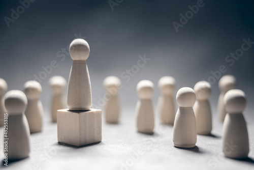 Leadership wooden business team with one person standing out from the crowd on podium