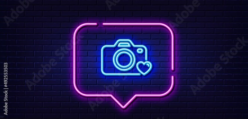 Neon light speech bubble. Photo camera line icon. Love photography sign. Heart symbol. Neon light background. Photo camera glow line. Brick wall banner. Vector