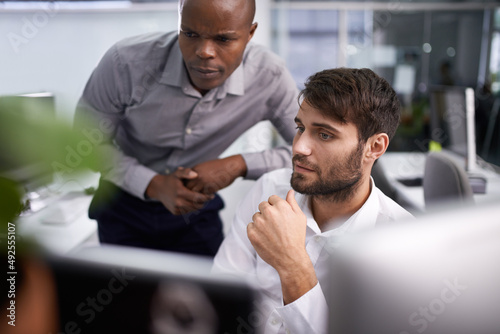 Success through technology. Shot of two businessmen looking at a computer.