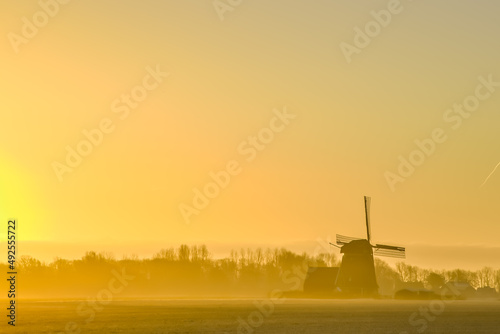 'Breezand, the Netherlands. March 2022. Sunrise in the polder with mill in background.