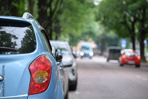 Cars parked in line on city street side. Urban traffic concept