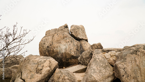 Climbing rocks, pine trees, scenery, and mountain silhouettes far away on a day with severe fine dust.
