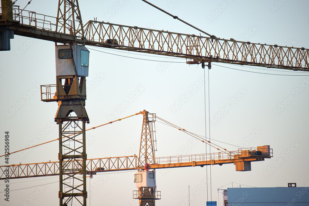 Tower cranes at high residential apartment buildings construction site. Real estate development