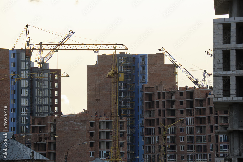 Tower cranes at high residential apartment buildings construction site. Real estate development Tower cranes at high residential apartment buildings construction site. Real estate development