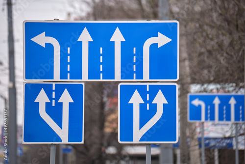 Photography Traffic sign pointing multiple road lanes direction on city street