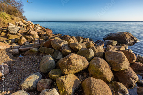 Denmark, Middelfart, 16.Dec. 2021 - Here from the beach, with bare trees, blue sky