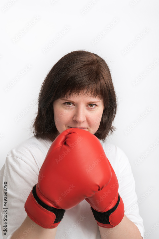 Portrait of dark-haired girl in boxing gloves on white background. Women rights event concept. Portrait of dark-haired girl in boxing gloves on white background. Women rights event concept.