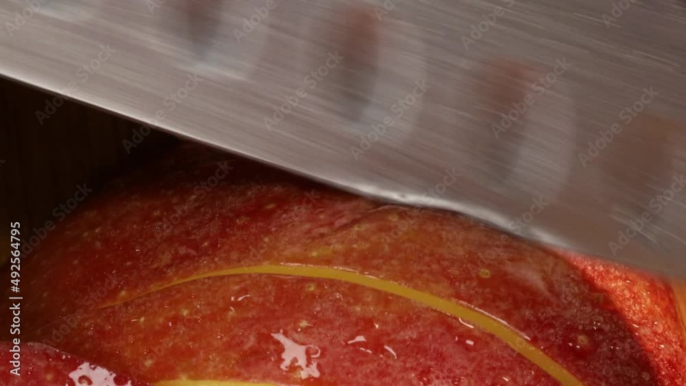 Chef slices and chops a fresh, big red apple slice on a wooden board. Sharp knife cuts apple in 4k macro shot close up. Chef slices and chops a fresh, big red apple slice on a wooden board. Sharp knife cuts apple in 4k macro shot close up.