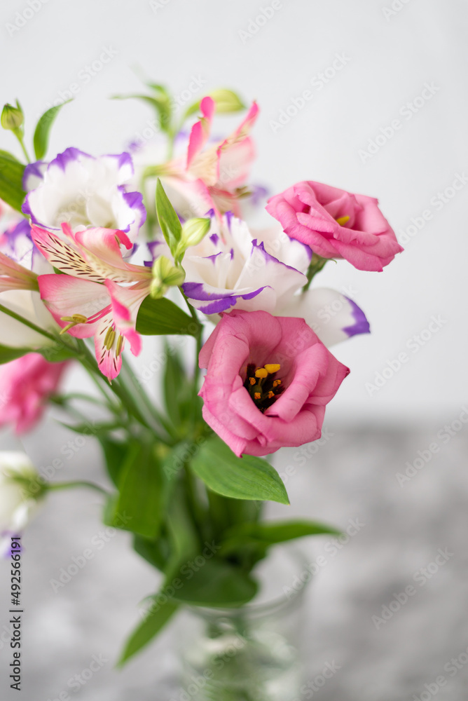Colorful flowers composition over grey background with copy space. Fresh cut flowers for decoration home. Flower arrangement in a vase for home. Women's Day and spring time flower background Colorful flowers composition over grey background with copy space. Fresh cut flowers for decoration home. Flower arrangement in a vase for home. Women's Day and spring time flower background