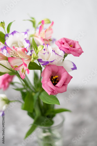 Colorful flowers composition over grey background with copy space. Fresh cut flowers for decoration home. Flower arrangement in a vase for home. Women s Day and spring time flower background