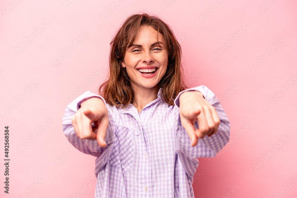 Young caucasian woman isolated on pink background cheerful smiles pointing to front. Young caucasian woman isolated on pink background cheerful smiles pointing to front.