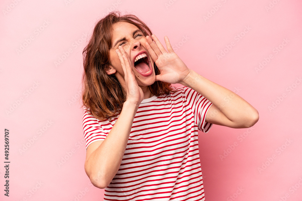 Young caucasian woman isolated on pink background shouting excited to front. Young caucasian woman isolated on pink background shouting excited to front.