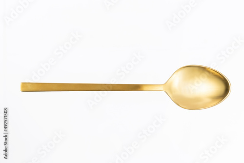 close-up of gold spoon on white background