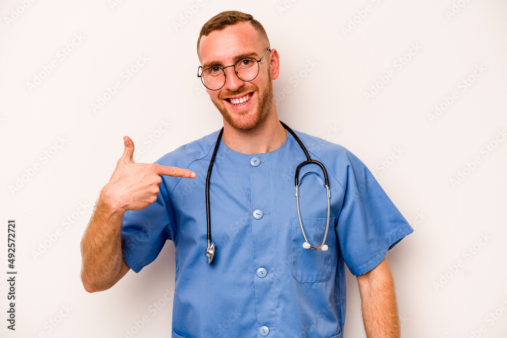Young caucasian nurse man isolated on white background person pointing by hand to a shirt copy space, proud and confident Young caucasian nurse man isolated on white background person pointing by hand to a shirt copy space, proud and confident