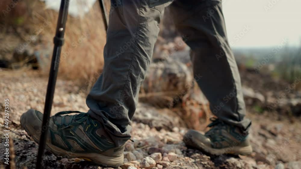 Close up mountaineering boots walking on rocky mountains at vacations outdoor. Tourist walks on adventure trip in natural at holidays. Travel lifestyle concept Close up mountaineering boots walking on rocky mountains at vacations outdoor. Tourist walks on adventure trip in natural at holidays. Travel lifestyle concept